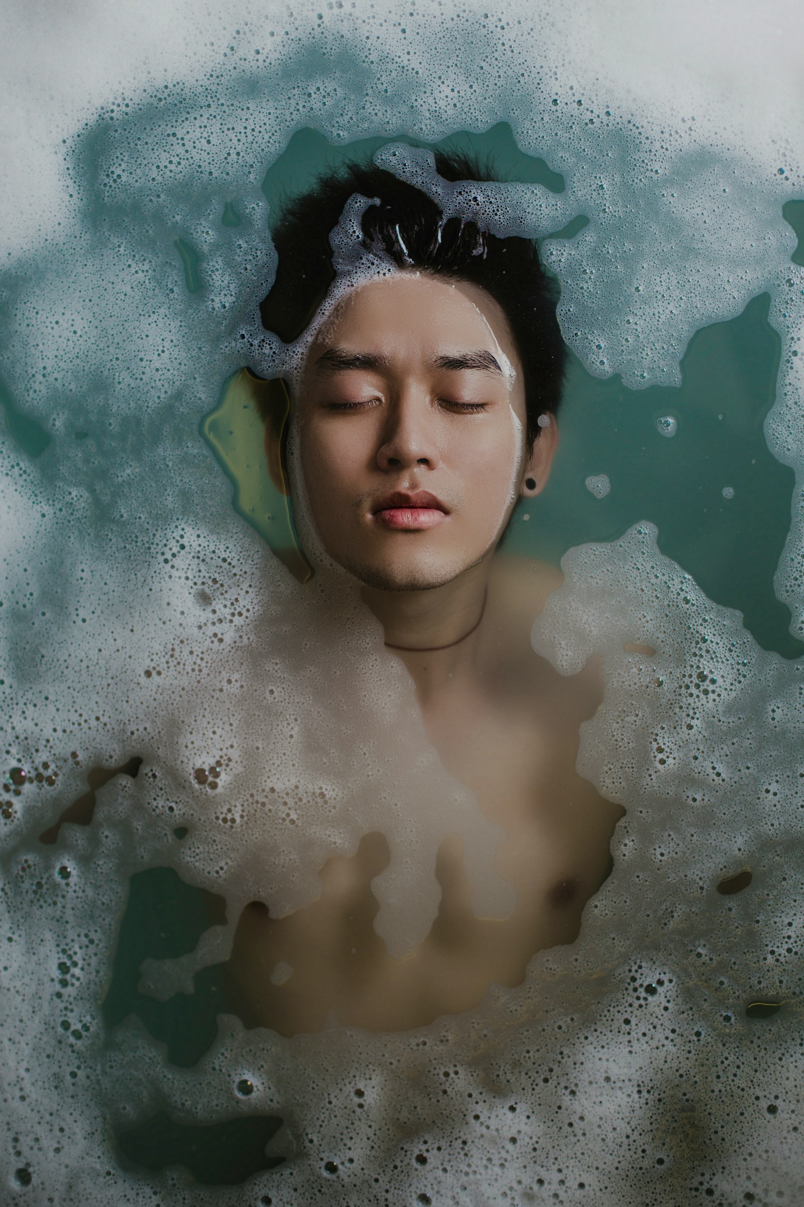 A swimmer lying back at the surface, face above the waterline